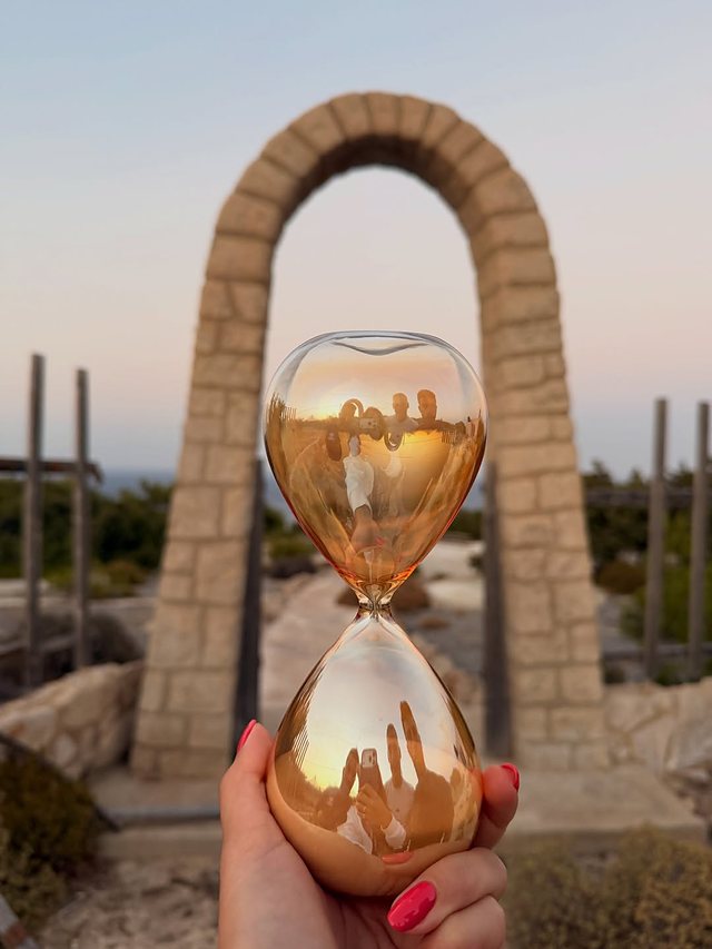 Κλεψύδρα μπροστά σε πέτρινη καμάρα την ώρα του ηλιοβασιλέματος